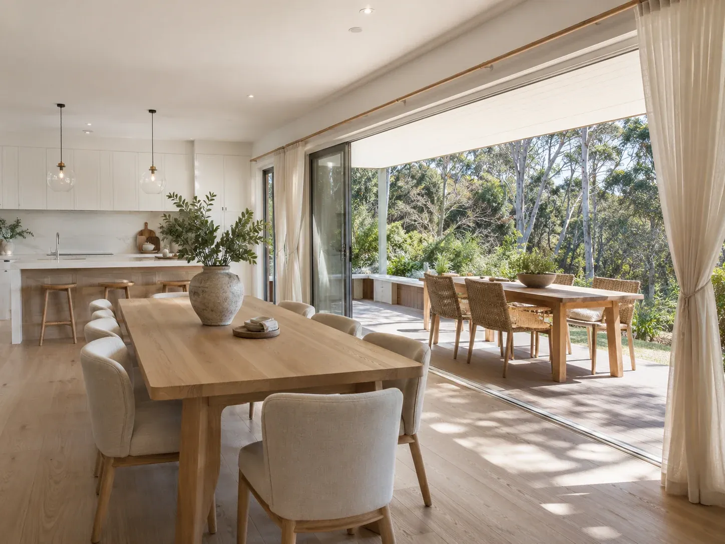 Australian open-plan living-dining space with stacked sliding doors open to a covered alfresco dining area