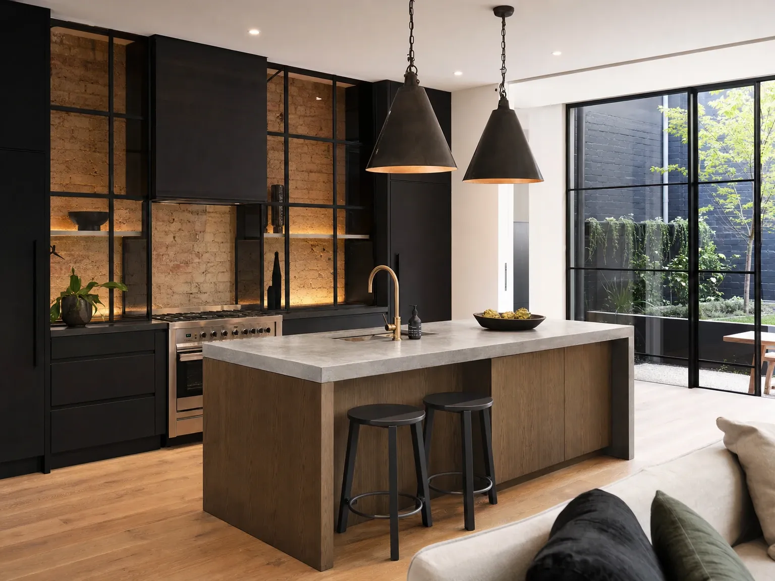 The same kitchen after an industrial renovation with matte black joinery and concrete bench