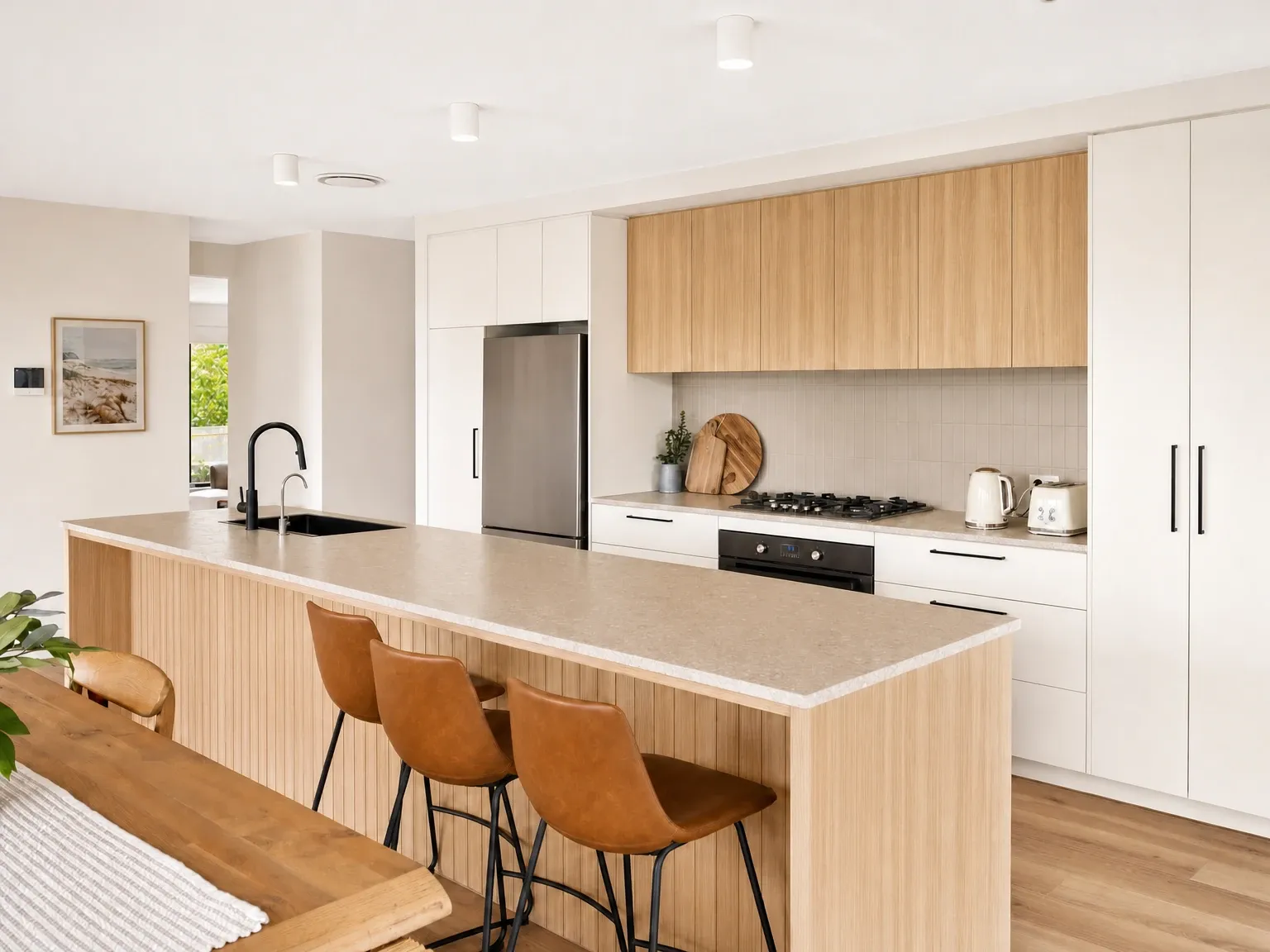 The same Australian kitchen with a cleared benchtop and one styled object on the island