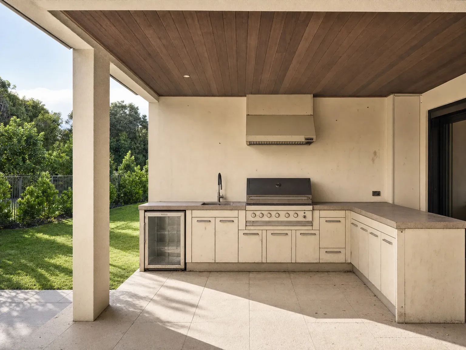 Tired alfresco corner with a freestanding BBQ before outdoor kitchen renovation