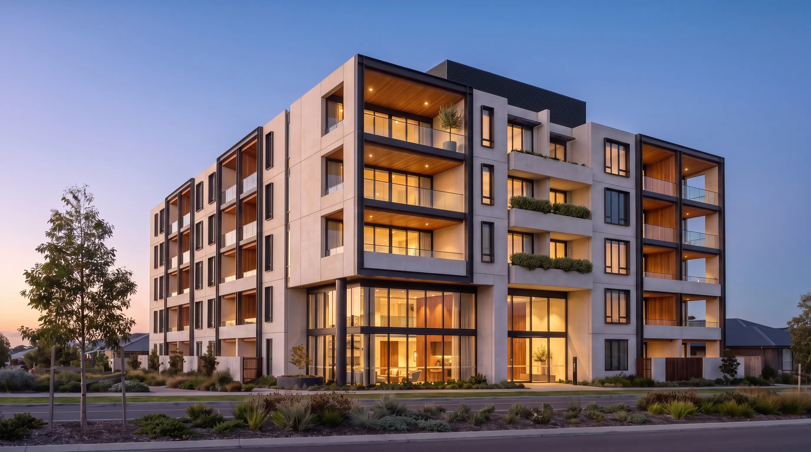 Apartment study: dusk campaign hero of a precast and steel apartment building, deep timber-lined balconies glowing warm above a double-height lobby