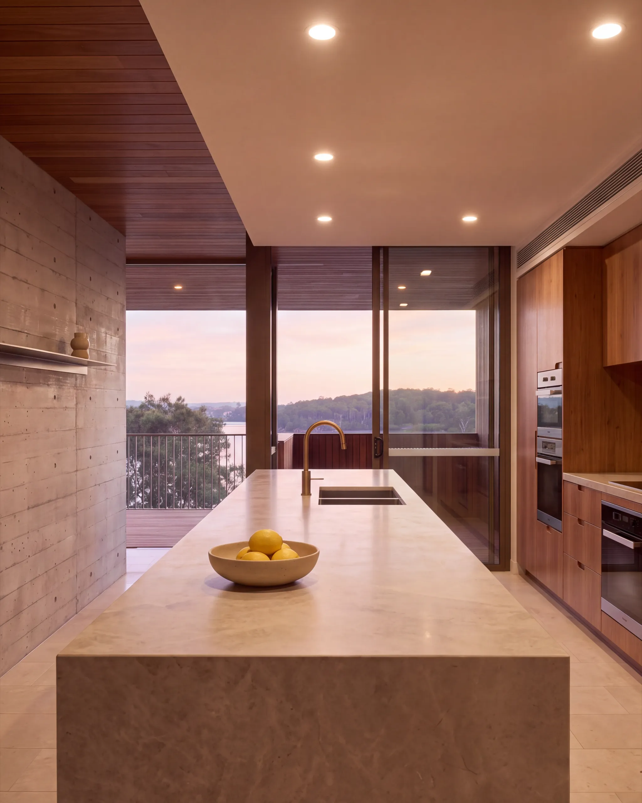 Carousel tile three: the kitchen, a limestone island and spotted gum joinery, dusk through the glass
