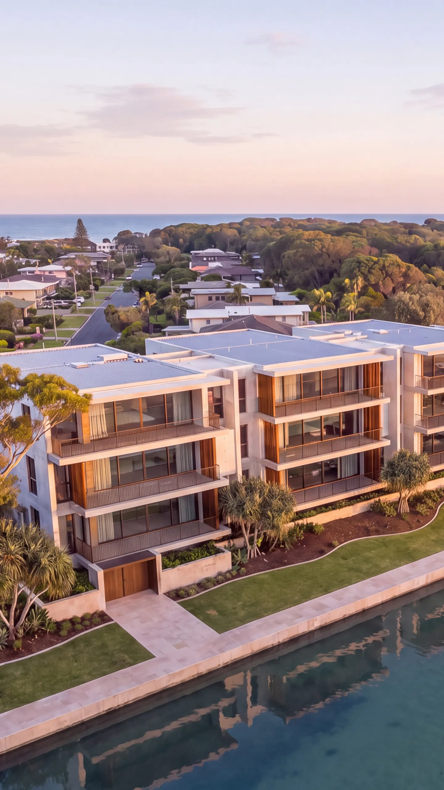 Story one: the apartment building from the air, on the creek below the wooded headland, the beach and ocean beyond