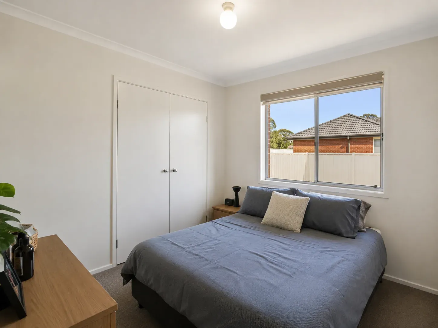 Typical 9 to 12 square metre Australian bedroom with queen bed, single window and built-in wardrobe