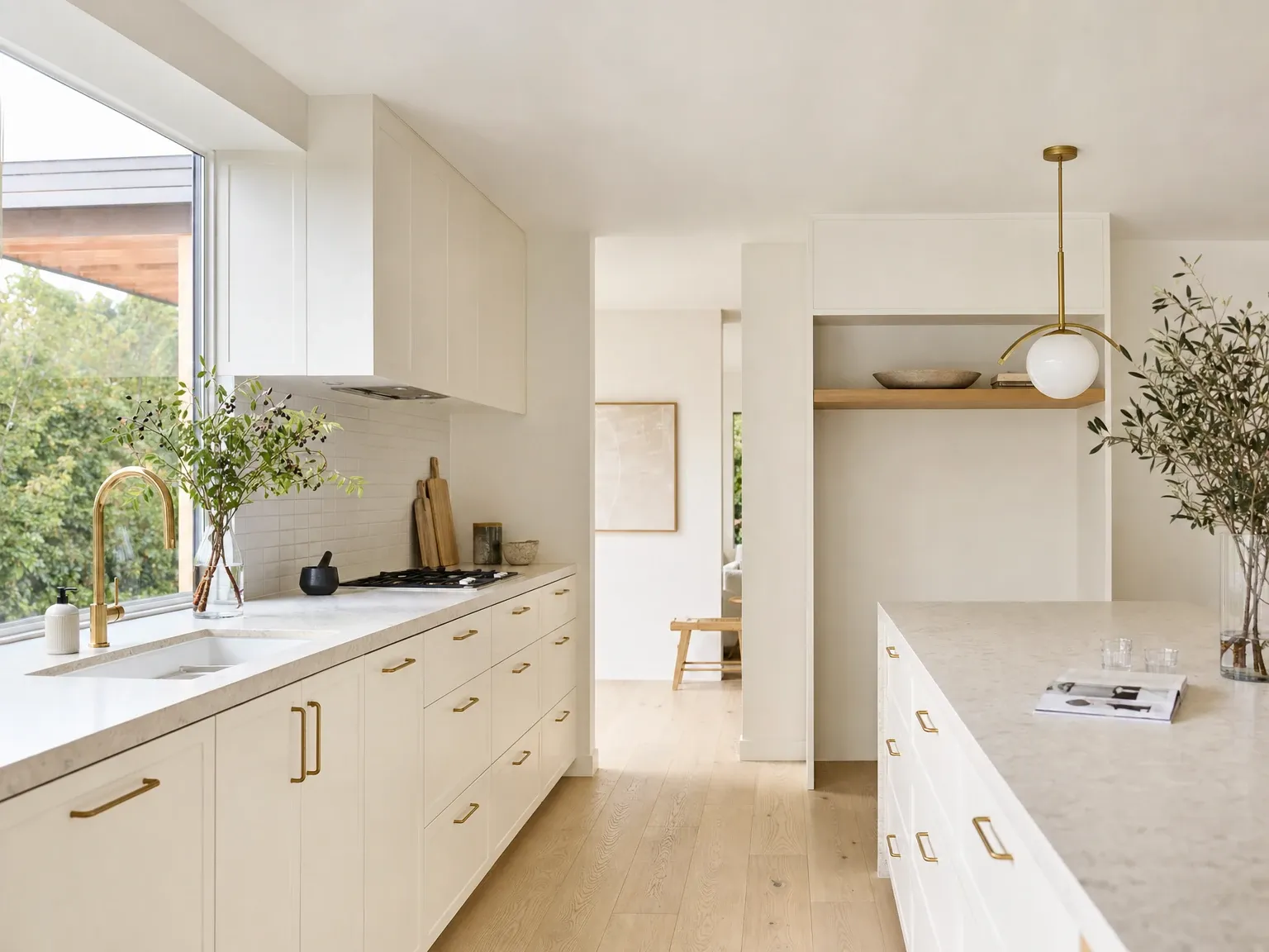 The same kitchen with warm matte white cabinetry, timber accents and layered contrast