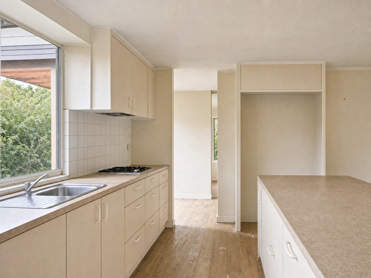 Cool bright white Australian kitchen cabinetry that reads dated under warm LED lighting