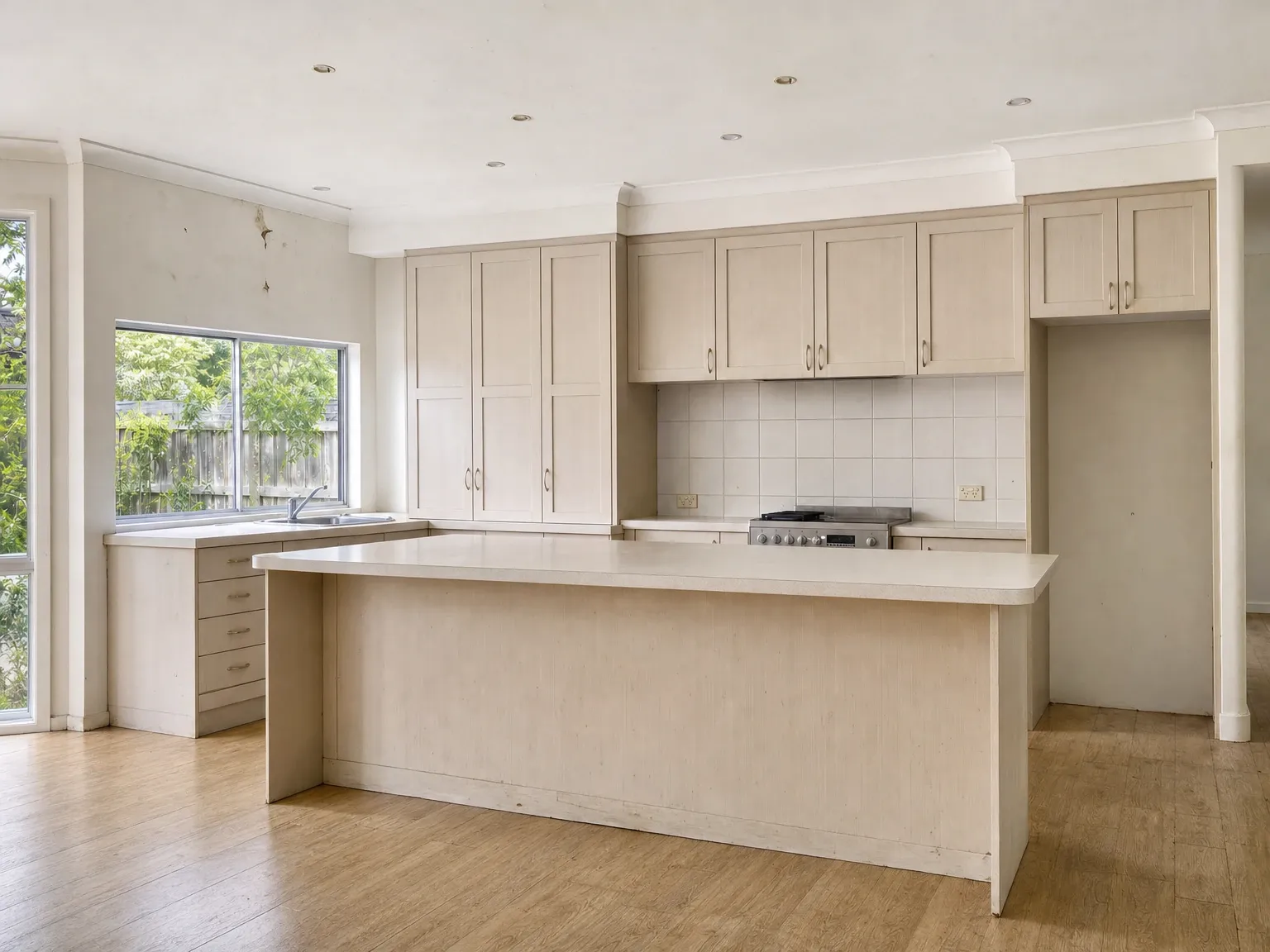 Cool all-white Australian kitchen with flat stone and no layered contrast